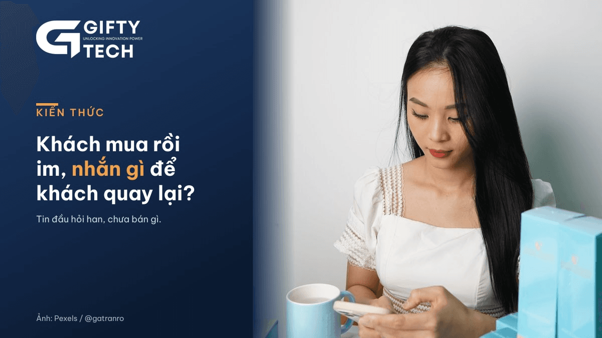 Ảnh minh họa: chị chủ shop mỹ phẩm ngồi bên bàn trắng ban ngày, cúi nhìn điện thoại và bấm tin nhắn, cạnh mấy hộp mỹ phẩm màu xanh và cốc nước. Ảnh: Pexels, Nguyễn Thị Minh Nghi (@gatranro)